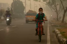 Indonesisk pojke som cyklar genom avgaser, på väg till skolan. Fotograf: Aulia Erlangga